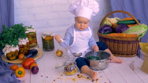 Adorável bebê macho criança na cozinha cozinhar, brincando com banco de lentilhas . — Vídeo de Stock