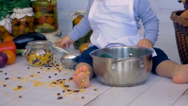 Очаровательный ребенок мужского пола на кухне приготовления пищи, играть с банком чечевицы . — стоковое видео