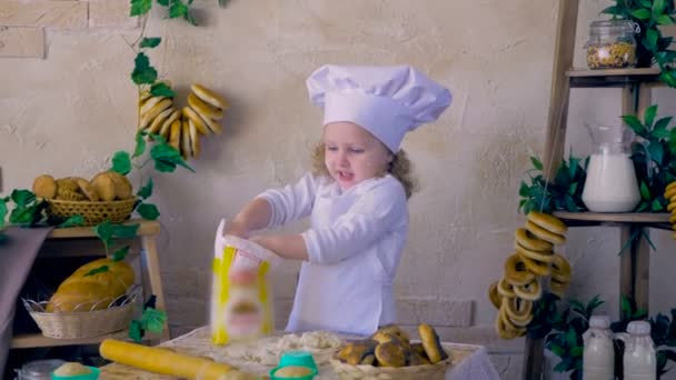 Adorable child girl cook in the kitchen playing with Flour. — Stock Video