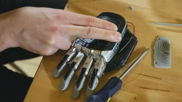 Человек собирает инновационную кибернетическую бионическую руку. Инновационные протезы . — стоковое видео