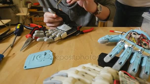 Человек создает инновационный продукт - роботизированную руку, напечатанную на 3D-принтере . — стоковое видео
