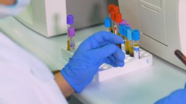 Bir laboratuvar test tüpleri ile çalışan bir bilim adamı. Yakın çekim.