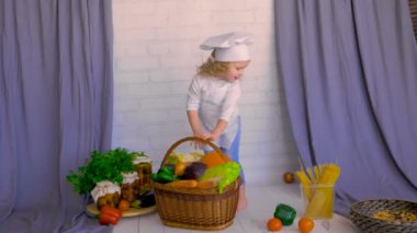 Chef şapka yakaladığında sepeti taze sebze ile kız. Sağlıklı gıda kavramı.