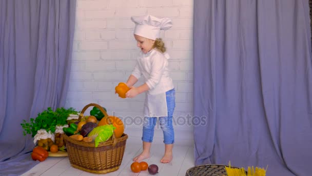 笑顔のかわいい子は、バスケットに野菜を入れてください。健康的な食事の概念 — ストック動画