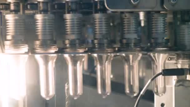 Las formas plásticas para botellas de PET se están calentando en equipos industriales de soplado de PET . — Vídeo de stock