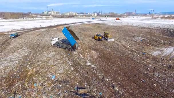 Ongewenste werf van bovenaf. Vuilniswagen lossen afval op een vuilnisbelt. Luchtfoto. — Stockvideo