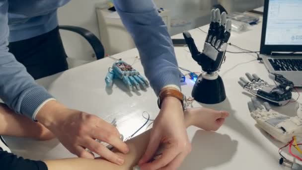 Ingenieur handen innovatieve bionic robotarm, moderne prothese aan de vrouwelijke kant instellen. — Stockvideo