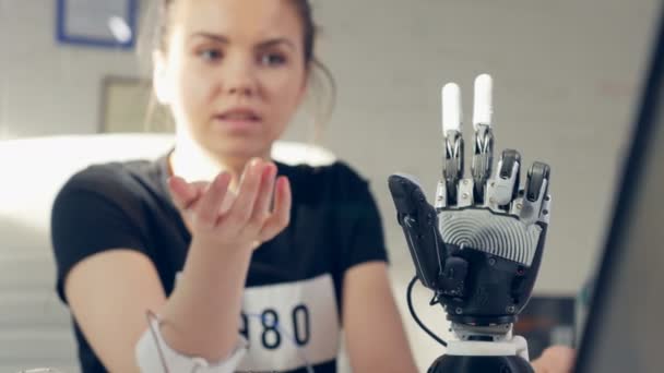 Жінка контролює електронну протезну руку за допомогою біонічної технології . — стокове відео