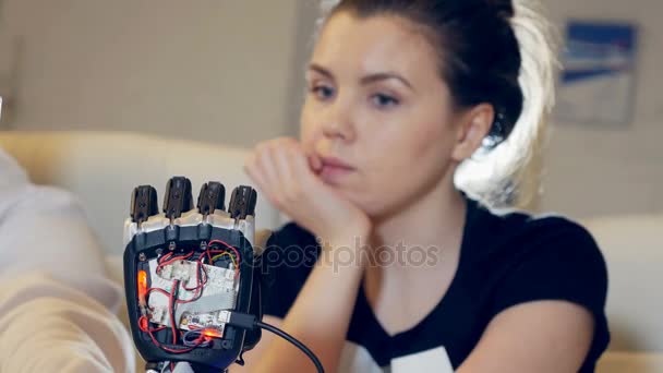 Human and robot meeting. Female look at modern robotic hand. Human-robotic relationship concept. — Stock Video