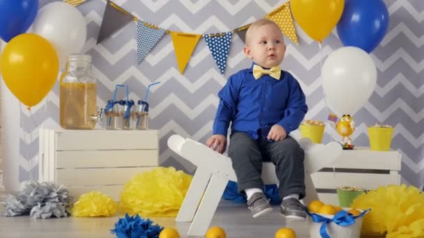 Um menino sério a sorrir. Aniversário festa decoração . — Vídeo de Stock