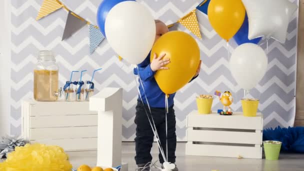 Щаслива дитина грає з повітряними кулями на день народження . — стокове відео