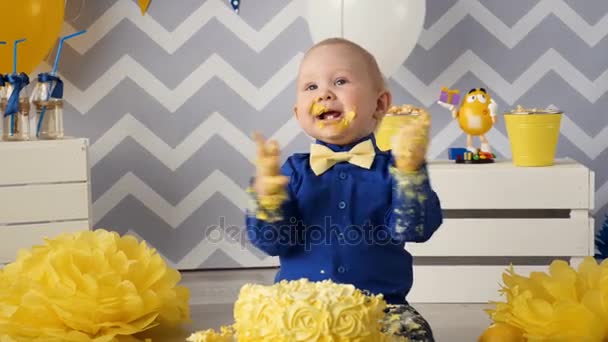 Веселый, счастливый мальчик, пожирающий торт руками. . — стоковое видео