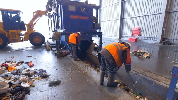 Lavoratori che selezionano rifiuti, immondizie in un trasportatore di impianti di riciclaggio . — Video Stock