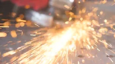 Ağır çekim. Sparks bir açıdan atılır kameraya değirmeni uçar. Değirmeni daire - yakın çekim.