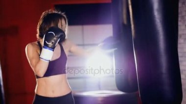 Spor salonunda eğitim, kum torbası boks kadın boksör.