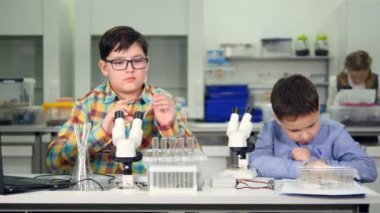 Genç erkek, kimya yapma Biyoloji okul laboratuarında deneyler..