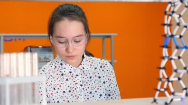 Kimyager liseli kız 10-11 yıl içinde gözlük kimyasal test tüpü içinde karıştırma.