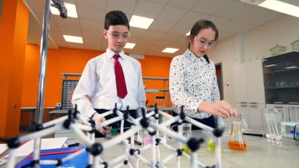 Estudiantes de escuela trabajando juntos en un proyecto de química en el aula de química . — Vídeos de Stock