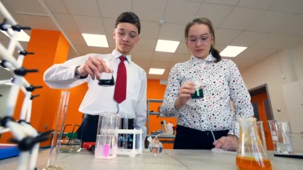 Estudiantes de primaria haciendo un experimento de química en un aula de ciencias . — Vídeo de stock