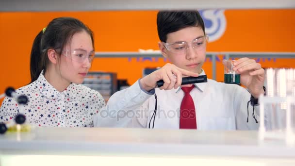 Studenten werken aan een chemie project samen in scheikunde klas op school. — Stockvideo