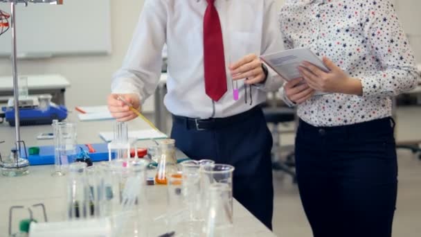 Werken aan een chemie project samen in scheikunde klas scholieren. — Stockvideo