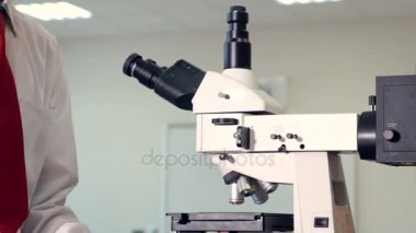 Biyoloji okuyan, mikroskop okul laboratuarında bakarak genç çocuk.
