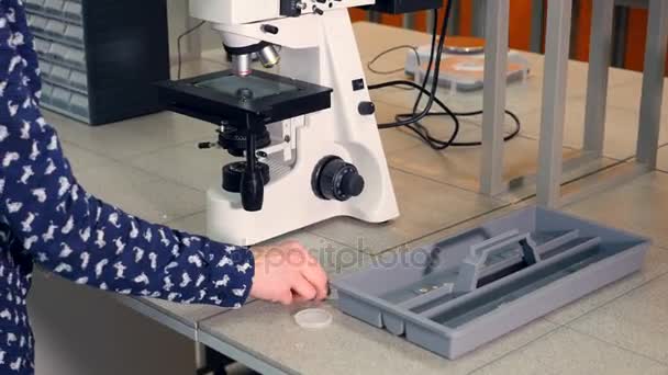 Шкільна дівчина дивиться в мікроскоп. Крупним планом . — стокове відео