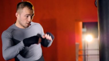 Güçlü atlet kum torbasına vurur. Ağır çekim.