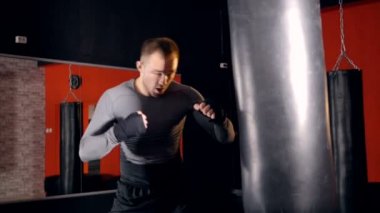 Fitness salonunda yakışıklı kickboks adam eğitim kum torbası.