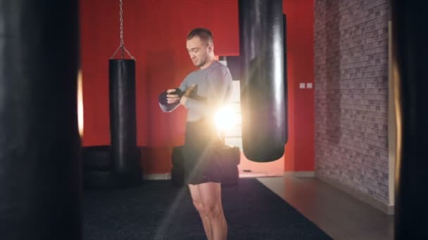 Boxer wrapping bandages on his hand before fight. Slow motion. — Stock Video