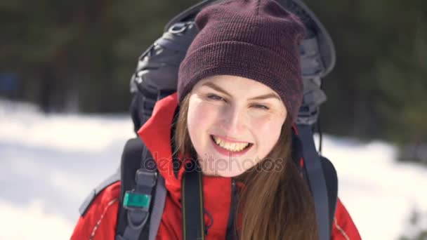 쾌활 한, 웃는 등산객 그녀의 모자를 벗어. 여행자, 겨울 숲에서 등산객 긍정적인 초상화입니다. 하이킹, 사랑, 순 결, 자유 개념. — 비디오