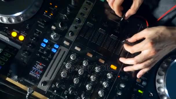 Närbild av en dj händer med mixer och skivspelare i nattklubb. — Stockvideo