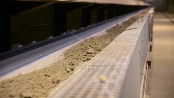 Mining industry. Close-up clay moving on conveyor belt in modern processing plant. Slider shot. — Stock Video