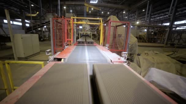 Cinta transportadora con ladrillos recién hechos en un piso de fábrica . — Vídeos de Stock