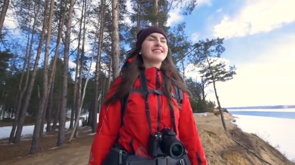 La niña está de pie en la orilla de la cima de la roca, respirando el aire fresco del bosque . — Vídeos de Stock