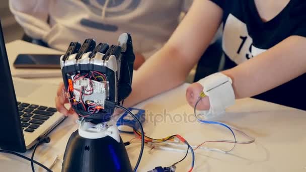 El brazo robot está reaccionando a los movimientos del brazo de las ladys discapacitadas . — Vídeos de Stock