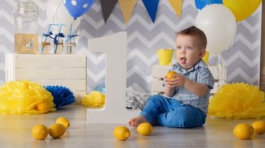 Çocuk limon ile oynuyor. Tatmak çalışıyor.