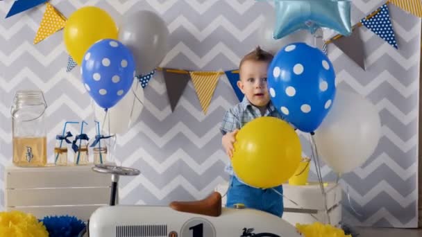 Söt 1 år pojke firar sin ett år födelsedag med ballonger. — Stockvideo