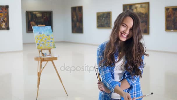 La jeune femme rieuse se frise les cheveux avec le pinceau. Gros plan portrait d'artiste. 4K . — Video