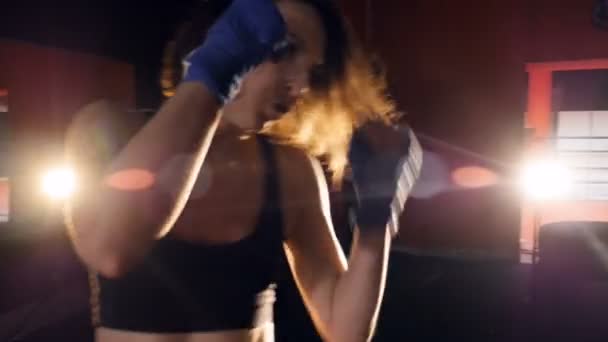 La chica boxeadora está entrenando con el saco de boxeo. Primer plano. 4K . — Vídeos de Stock