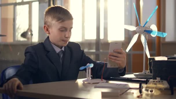 Menino da escola configurar painéis solares e gerador de vento no laboratório da escola . — Vídeo de Stock