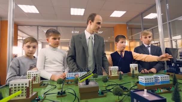 Professor com alunos da escola estudando sobre o poder alternativo no laboratório da escola. 4K . — Vídeo de Stock