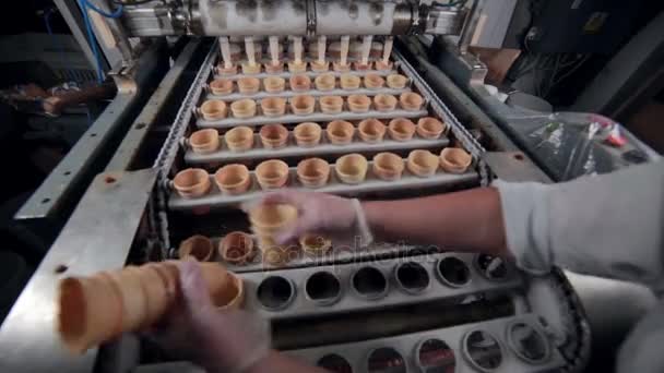 De werknemer wordt de ice - cream cones ingevoegd in de speciale gaten. Close-up. Timelapse. — Stockvideo