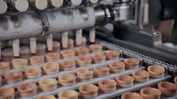 A máquina está enchendo cones de sorvete com sorvete. Close-up. HD . — Vídeo de Stock