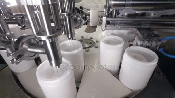 La macchina industriale versa il liquido nelle bottiglie in PET. 4K . — Video Stock
