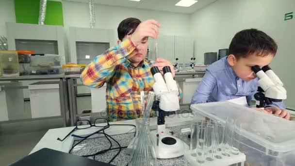 실험실에서 샘플을 공부 하는 젊은 과학자 소년. 클로즈업입니다. 4 k. — 비디오