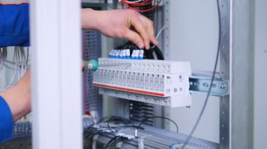 Tanınmayan adam bağlantıları'nda sigorta kutusu, elektrik raf takılır. Yakın çekim. 4k.
