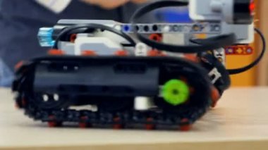 Yakın çekim. Caterpillar robot komutları veren çocuk. 4k.