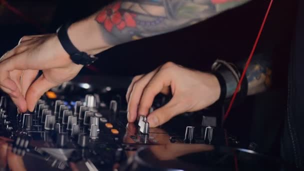 DJ hands turning volume control, creating music in the disco light. Close-up. HD. — Stock Video