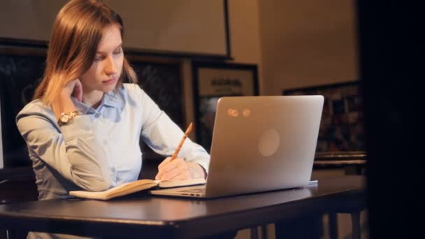 La chica toma notas antes de la computadora. Retrato. 4K . — Vídeo de stock